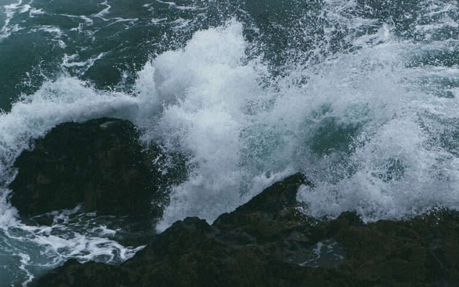 Waves crashing against rocky shoreline.